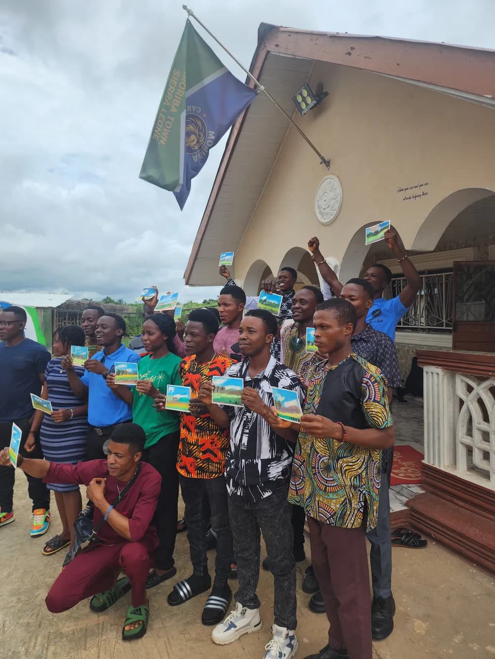 Students holding certificates outside the school